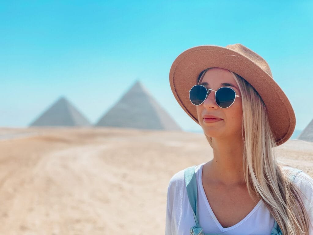 Standing in the desert with the Pyramids of Giza in the background after traveling to Egypt as a woman.