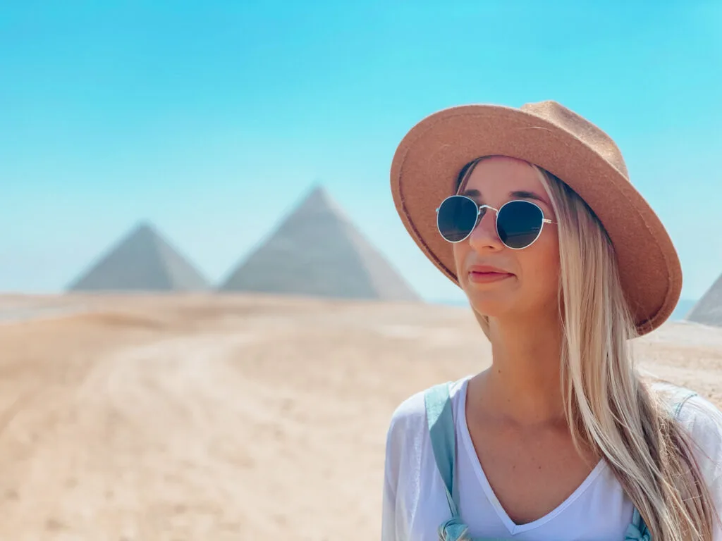 Standing in the desert with the Pyramids of Giza in the background after traveling to Egypt as a woman.