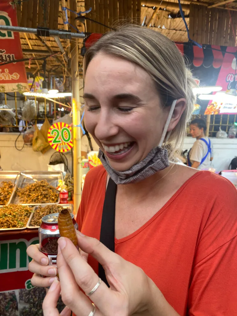 Trying a silk worm in Thailand