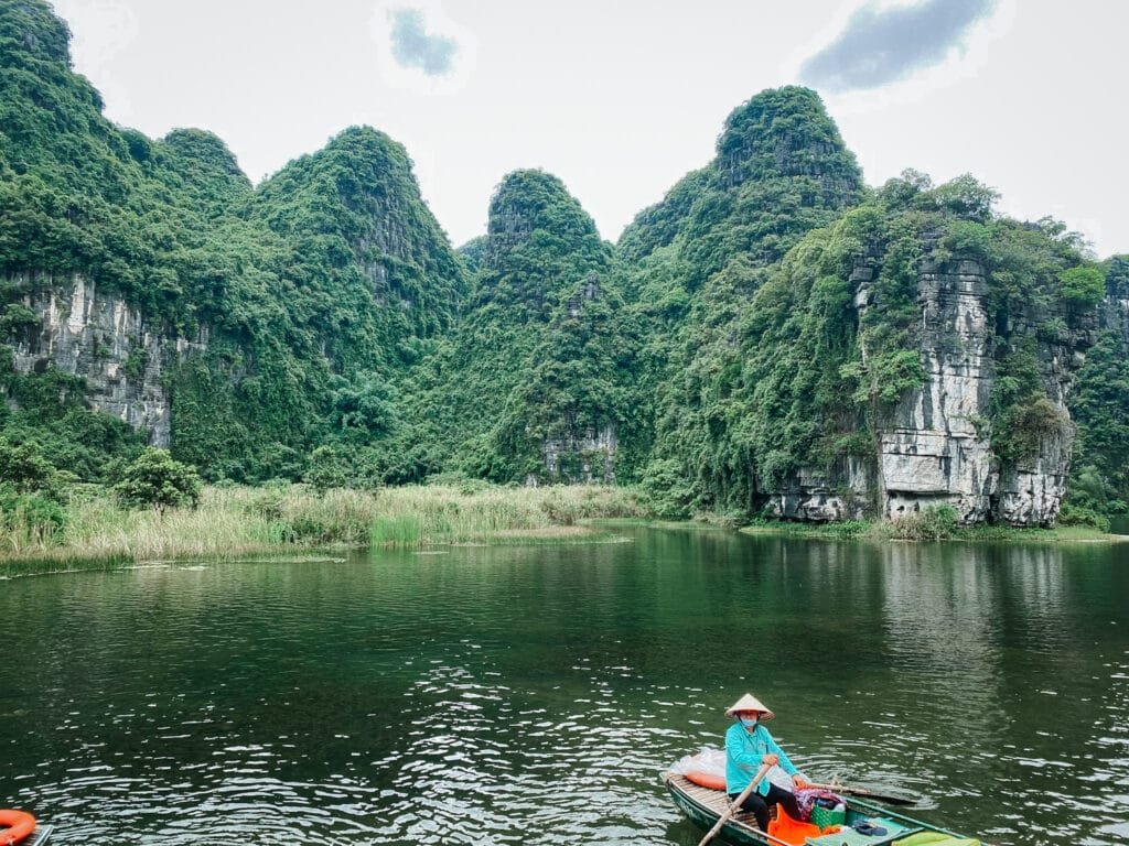 A picture of a boato n the river on the Trang An Boat Tour. The Trang An Boat tour is one of the top things to do in Ninh Binh