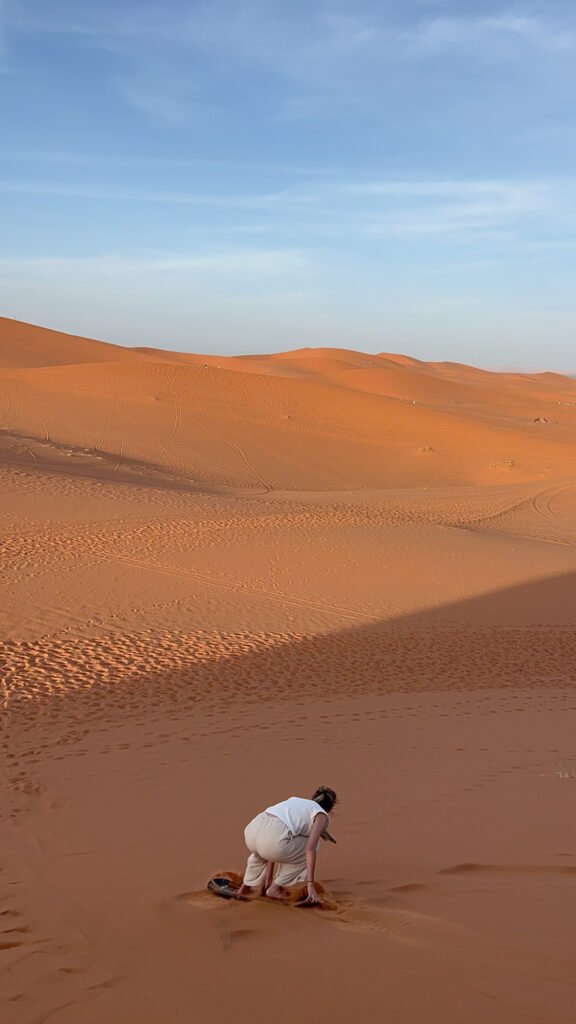 sandboarding on the sand dunes in the sahara desert in Morocco