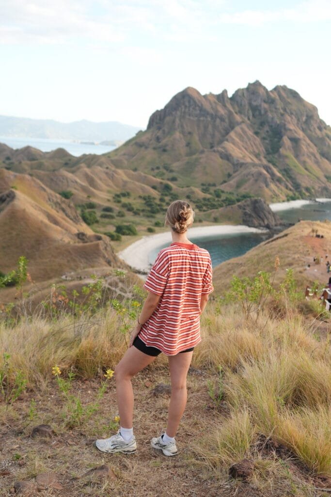 Woman looking over the viewpoint of Padar Island in Indonesia. A part of a Komodo Liveaboard during a 3 weeks in Indonesia itinerary for a solo female.