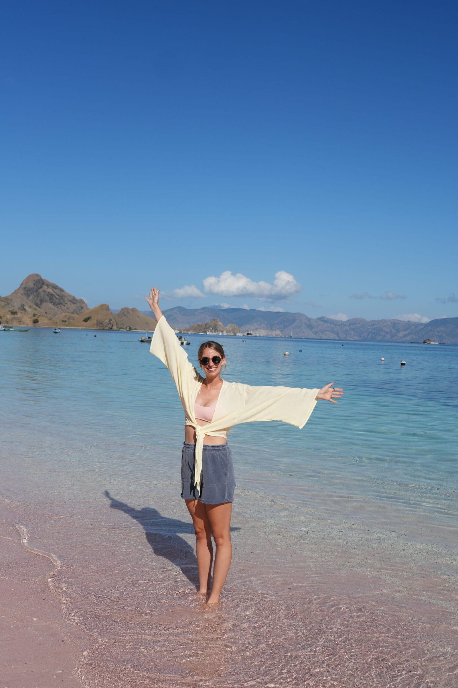 A woman standing on the Pink Beach in Indonesia