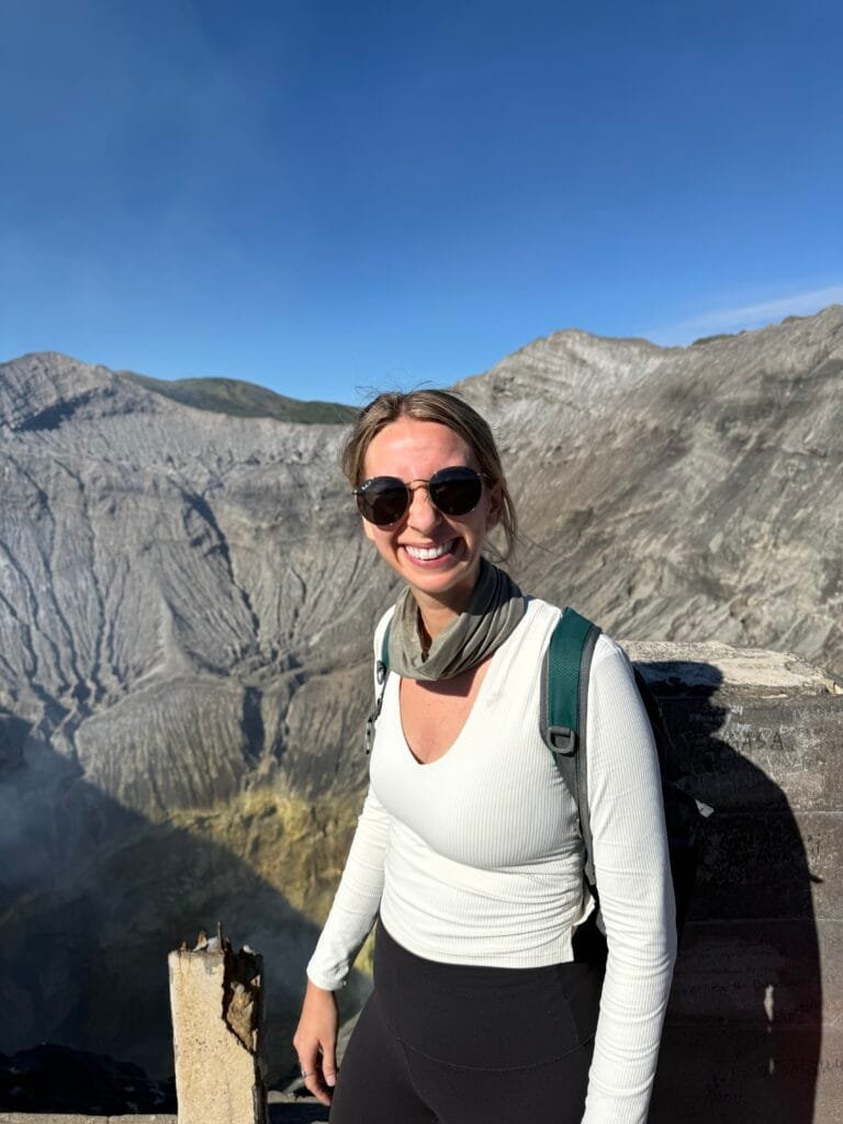 Young woman smiling at the crater of Mt. Bromo in Indonesia