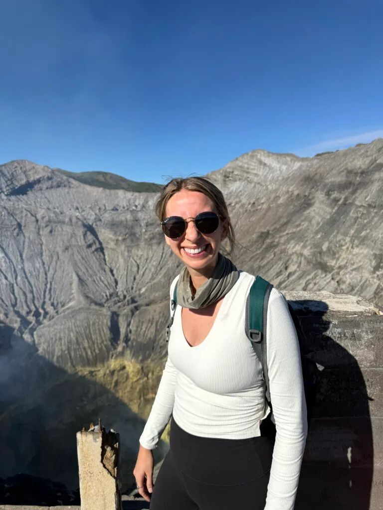 Young woman smiling at the crater of Mt. Bromo in Indonesia