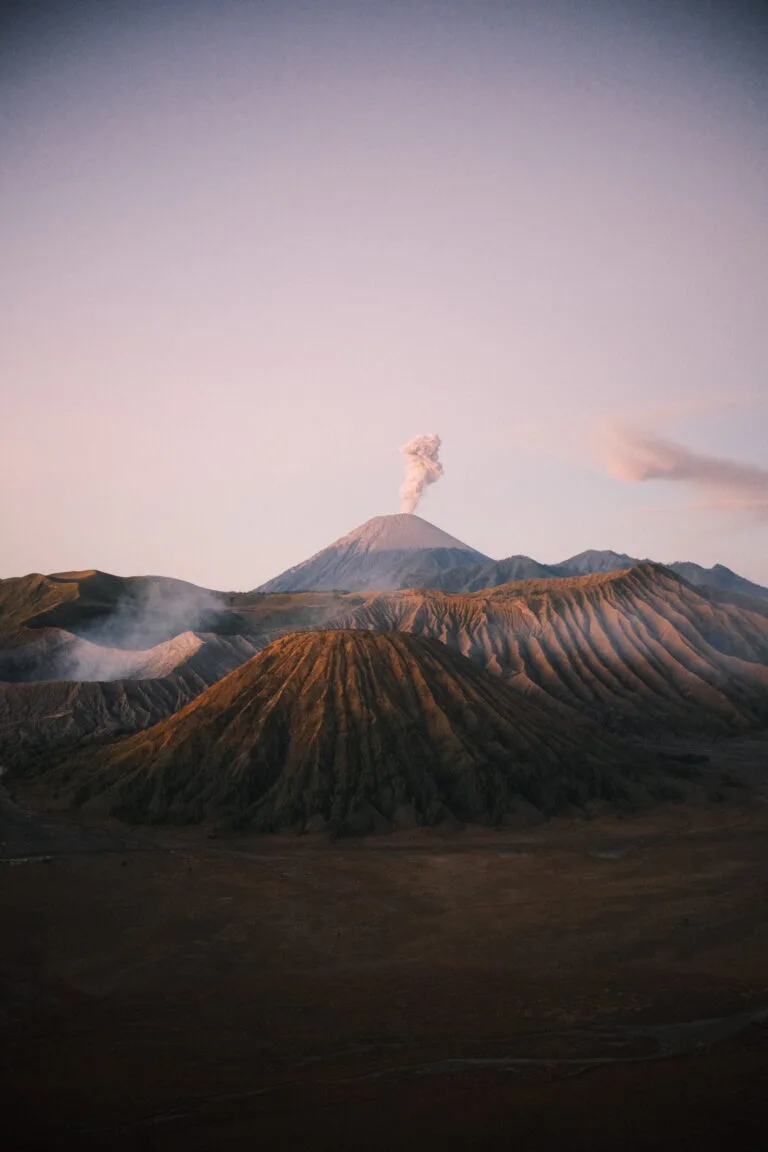 Pinkish glow of the sunrise hitting Mt Bromo after a sunrise hike in Indonesia