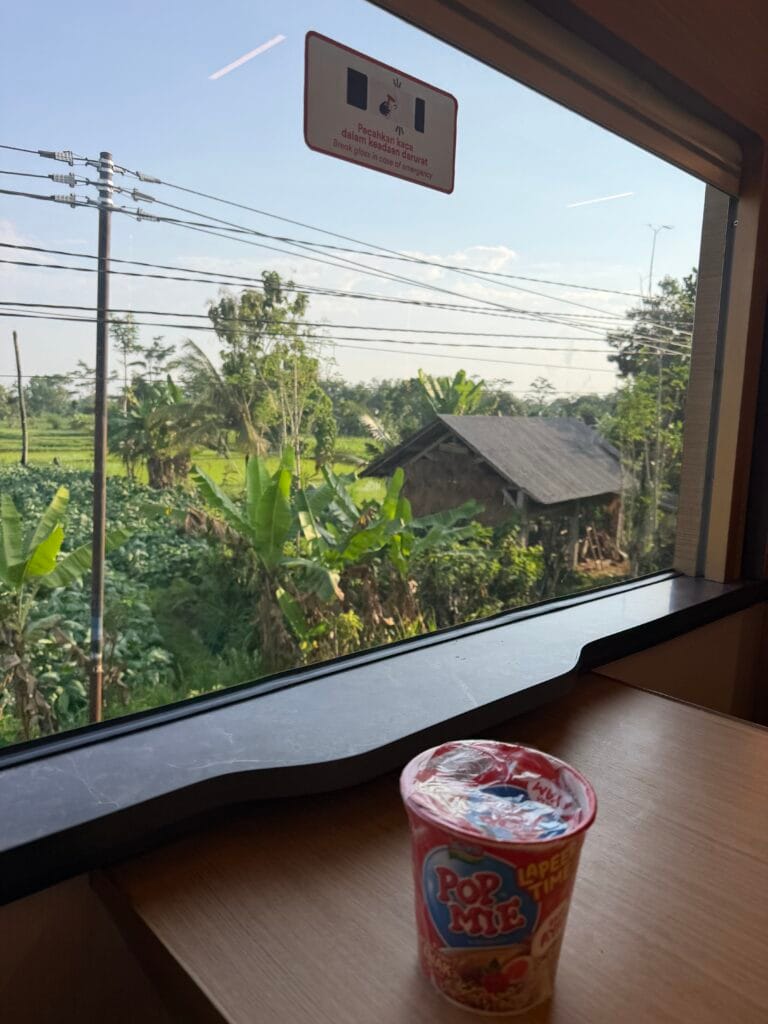cup of noodles in the dining car on a train overlooking the rice fields in Indonesia