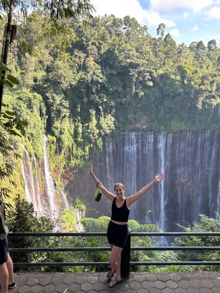 Woman standing at the lookout point of Tempak Sewu waterfall in Indonesia