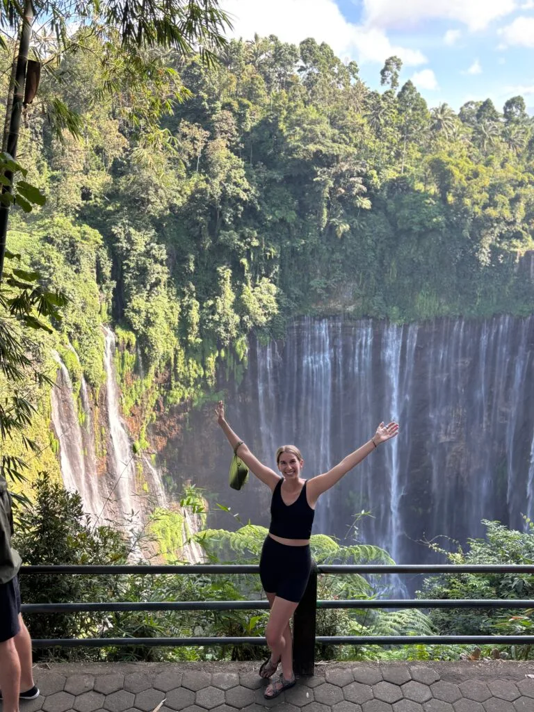 Woman standing at the lookout point of Tempak Sewu waterfall in Indonesia